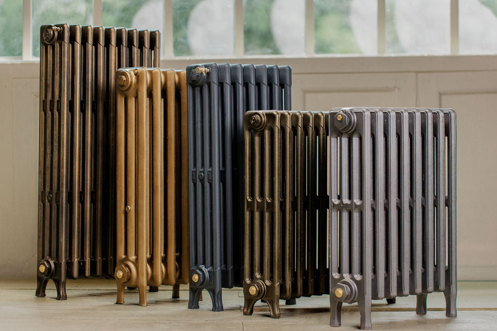 Group of five antique column style cast iron radiators in a rustic style shop