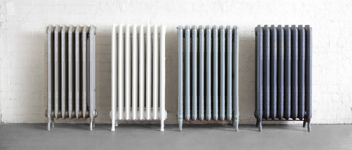 Four different coloured antique cast iron radiators
